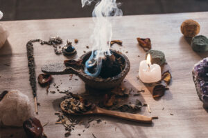incense holder with burning charcoal, incense resin, and myrrh on a rustic wooden table